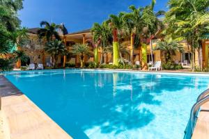 a swimming pool in front of a house with palm trees at Coconut Beach Resort, Koh Chang in Ko Chang