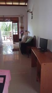 a living room with a couch and a desk with a computer at chamika house in Matara
