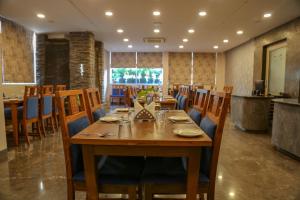 a dining room with a long wooden table and chairs at Four Leaf Hotel - Sapphire Blue, Varanasi in Varanasi
