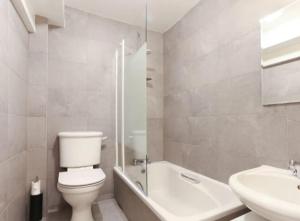 uma casa de banho branca com um WC e um lavatório em Barbican Pad by condokeeper em Londres