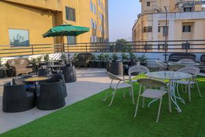 Four Leaf Hotel - Sapphire Blue, Varanasi في فاراناسي: فناء به طاولات وكراسي ومظلة