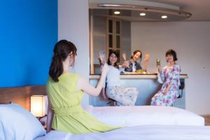 a group of women sitting on a bed drinking champagne at Rycom Family Resort Hotel in Okinawa City