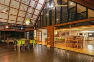 a room with a table and chairs and a living room at ZenLux: 3-Story Corporate Golf Retreat + Pool/BBQ in Knuckeys Lagoon