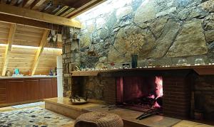 a fireplace in a room with a stone wall at Chalet in the Forest in Kalavrita