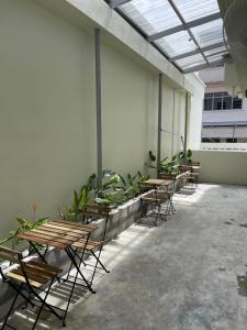 a group of tables and chairs in a room with plants at Ninety Guest House in Ipoh