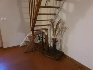 una escalera con un jarrón y una planta en una habitación en La fermette des Étangs, en Crux-la-Ville