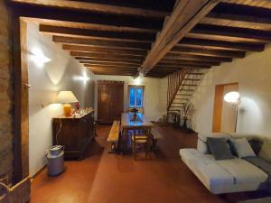 ein Wohnzimmer mit einem Sofa und einem Tisch in der Unterkunft La fermette des Étangs in Crux-la-Ville
