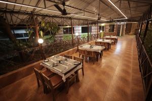um restaurante com mesas e cadeiras num edifício em EliteHotels and Resorts Pvt Ltd em Alibaug