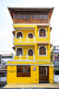 a yellow building with a wooden roof at The Barracks Cochin in Cochin