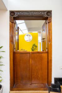 a wooden door in a hallway with a yellow wall at The Barracks Cochin in Cochin