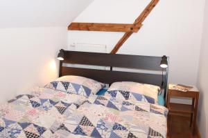 a bed with a quilt and two pillows on it at Ferienwohnung auf der Rübenburg in Barnsen