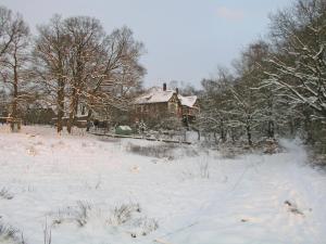 a house in a field covered in snow at Ferienwohnung auf der Rübenburg in Barnsen