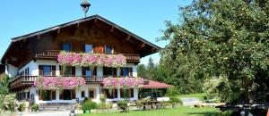 une maison avec des fleurs à l'avant dans l'établissement Oberachenhof, à Ellmau