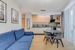 a living room with a blue couch and a table at Aura 40 City Center & Free Parking by Downtown Apartments in Gdańsk +31 photos