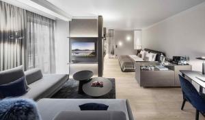 a living room with a couch and a bed in a room at Hotel Weisses Roessl in Kitzb&uuml;hel