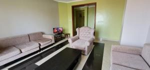 sala de estar con sofá y 2 sillas en Traveller's StaY, en Kigali