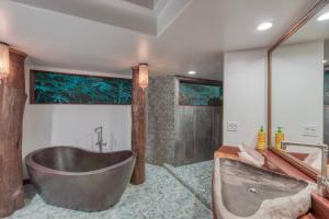 a bathroom with a large tub and a shower at The Kulani Maui in Lahaina