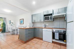 a kitchen with stainless steel appliances and a table at Terrapin Apartment 4 in Noosaville