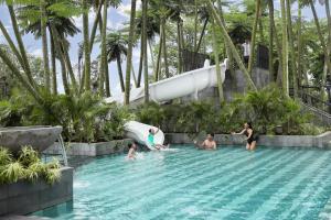 a group of people in a swimming pool at a resort at Padma Hotel Semarang in Semarang