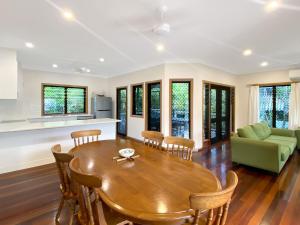 cocina y sala de estar con mesa de madera y sillas en Mills Cottage, en Arcadia