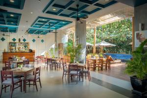 a restaurant with tables and chairs and a pool at Landing Gold by Amatak in Siem Reap