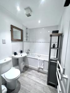 ein Badezimmer mit einem WC, einem Waschbecken und einer Badewanne in der Unterkunft Cydel Court in Kidlington