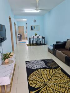 a living room with a couch and a rug on the floor at HOMESTAY ALFARUQI GAMBANG (5) in Kampong Pohoi