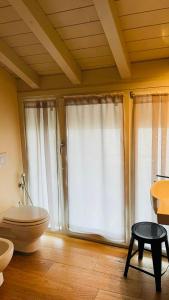 y baño con aseo, bañera y ventanas. en Relais La Rocca Solferino, en Solferino