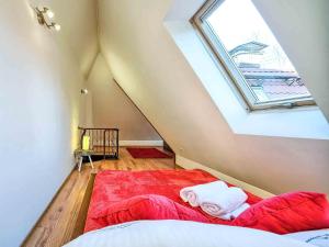 ザコパネにあるVisitZakopane - Mountain Apartmentの屋根裏のベッドルーム(赤いベッド1台、天窓付)
