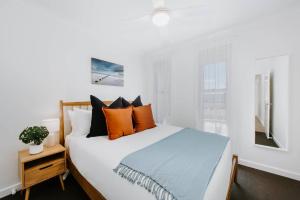 - une chambre dotée d'un lit avec des oreillers orange et bleu dans l'établissement Helvetia - Modern Comfort meets Country Convenience, à Mudgee