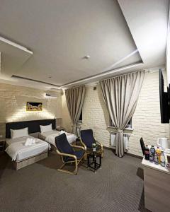 タシュケントにあるAl Arda HOTELのホテルルーム ベッド2台&椅子2脚付
