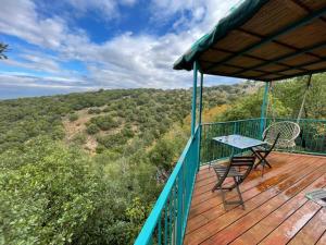 eine Holzterrasse mit einem Tisch und Stühlen darauf in der Unterkunft היורטוב במתת in Mattat