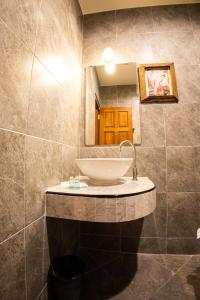 W łazience znajduje się umywalka i lustro. w obiekcie Rico's Patong Hotel w Patong Beach