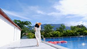 a woman standing on the edge of a swimming pool at Prek Kdat Resort in Kampot