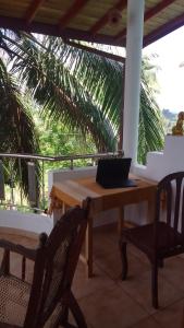 a laptop computer sitting on a wooden table on a balcony at chamika house in Matara