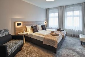 Pokój hotelowy z dużym łóżkiem i kanapą w obiekcie Hotel Via Regia - VIAs-Hotels w mieście Görlitz