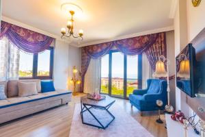 a living room with blue furniture and large windows at Fera Life Suit Apart in Trabzon