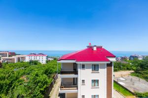 a white building with a red roof with the ocean in the background at Fera Life Suit Apart in Trabzon