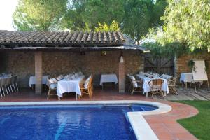 d'une terrasse avec des tables et des chaises à côté de la piscine. dans l'établissement Mas Falgarona Hotel Boutique & SPA, à Avinyonet de Puigventós