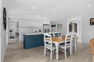 une cuisine et une salle à manger avec une table et des chaises en bois dans l'établissement Whai Awa Retreat - Mangawhai Holiday Home, à Mangawhai