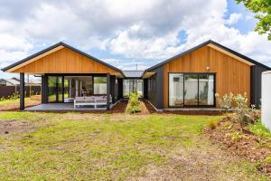 uma grande casa de madeira com um quintal em Whai Awa Retreat - Mangawhai Holiday Home em Mangawhai