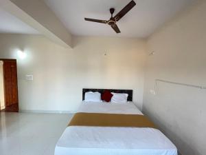 a bedroom with a bed with a ceiling fan at STAYMAKER CP Residency in Mysore