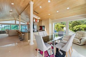 a dining room and living room with a table and chairs at Swallows Nest - Paihia Holiday Home in Paihia