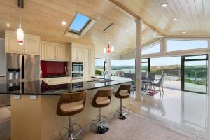 a kitchen with a large island with bar stools at Swallows Nest - Paihia Holiday Home in Paihia