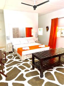 1 dormitorio con cama y banco. en Luwa Beach&Suits, en Watamu