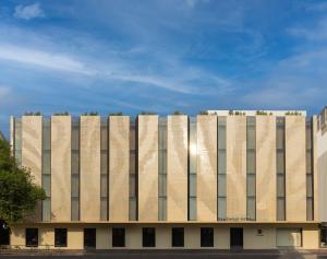 a tan building with trees on top of it at The Ember Hotel Khaosan in Bangkok