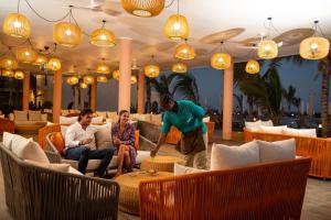 a man standing in a living room with three people at The Mora Zanzibar - Luxury All Inclusive in Matemwe +37 photos
