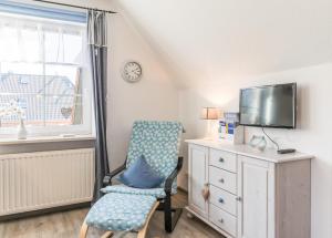 ein Schlafzimmer mit einem Stuhl, einem TV und einer Kommode in der Unterkunft "Appartement Kügler" Appartement Kügler in Reinsbüttel