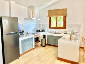 a kitchen with a stainless steel refrigerator and a counter at Kalulushi Bungalows in Haad Pleayleam