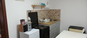 uma pequena cozinha com fogão e micro-ondas em Apartmani Lina em Ribarska Banja